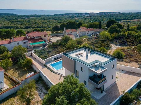 A modern villa with a swimming pool and a panoramic view of the sea near Poreč is for sale. The villa is located in a quiet location surrounded by nature and greenery. The area of ​​the villa is 390 m2 on three floors, basement, ground floor and firs...