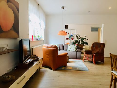 A separate entrance leads into the bright, friendly apartment. It consists of a large room with a cozy sitting area and dining area. The original retro kitchen in lively orange catches the eye. It is equipped with a dishwasher, stove with oven and mi...