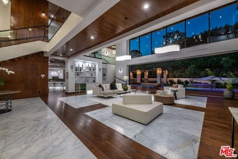 Stunning newly constructed Contemporary estate situated up a private gated driveway on an over half-acre lot in prime lower Bel Air. Perched on a knoll above Sunset Blvd and overlooking city, canyon, and ocean views, this property was designed for en...