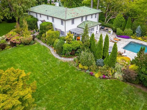 Just beyond the mature hedges, a magnificent Mediterranean Revival awaits. Sited on a generous lot, the extensive grounds feature manicured lawns, cheerful gardens and a private pool. The patio which sits adjacent to the kitchen has an outdoor firepl...