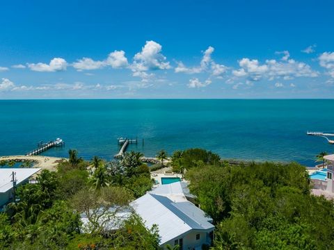 Tropical Bayfront Estate nestled into almost 2 lushly landscaped private acres. Everything you could possibly need is right here! Main House, Guest House, Pool, Pool Apartment, Storage Building, Dock, Boat Basin, Boat Ramp, Boat Lift, and UNBELIEVABL...
