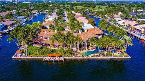 Gated Palatial Palm Beach-Inspired Point Estate sited in the prestigious Coral Ridge Country Club enclave on over 1.09 acre +/- framed by 3 amazing sides of wrap-around water frontage totaling 665 ft +/- of full-service mega-yacht dockage. This Troph...