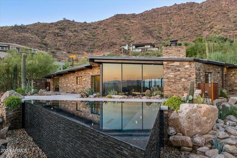 This Mid-Century Modern is truly a one of kind work of art situated on Camelback Mountain. Escape into the peace and tranquility of a home built to be a part of the Mountain with your own personal botanical garden and views from Camelback to Four Pea...